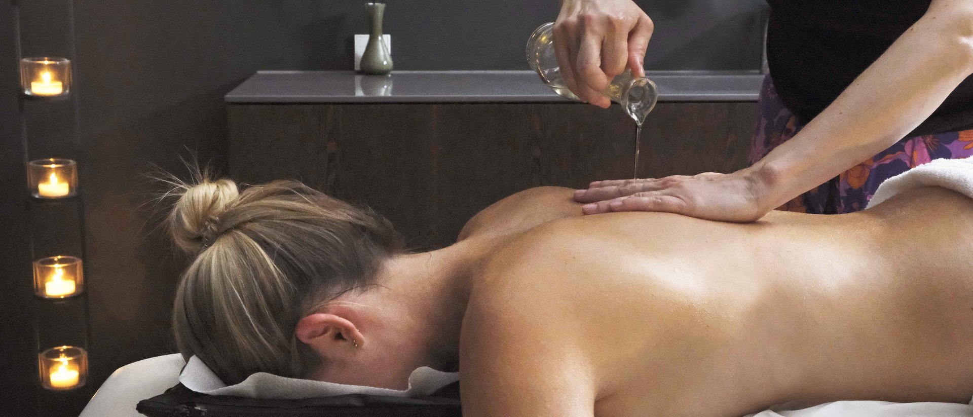 Longevity im Hotel in Deutschland im Allgäu Frau erhält Ölmassage auf Rücken in einem ruhigen Spa-Raum