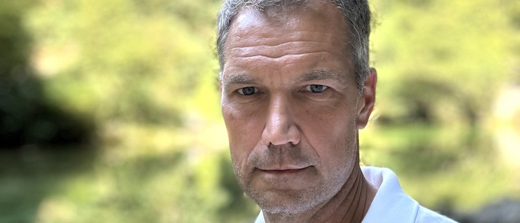 Wissen, das inspiriert: Unsere Vortragsreihe greift Themen auf, die das Leben bereichern. Nahaufnahme eines ernst blickenden Mannes vor unscharf grünem Hintergrund