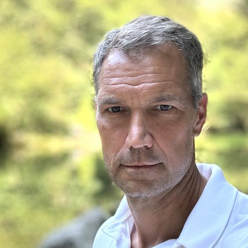 Wissen, das inspiriert: Unsere Vortragsreihe greift Themen auf, die das Leben bereichern. Nahaufnahme eines ernst blickenden Mannes vor unscharf grünem Hintergrund