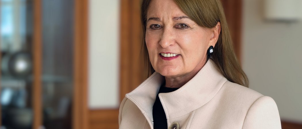 Wissen, das inspiriert: Unsere Vortragsreihe greift Themen auf, die das Leben bereichern. Porträt einer älteren Frau mit beige Mantel in einem Innenraum