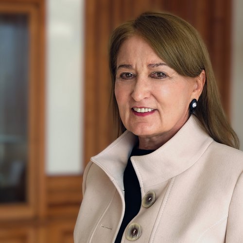 Wissen, das inspiriert: Unsere Vortragsreihe greift Themen auf, die das Leben bereichern. Porträt einer älteren Frau mit beige Mantel in einem Innenraum