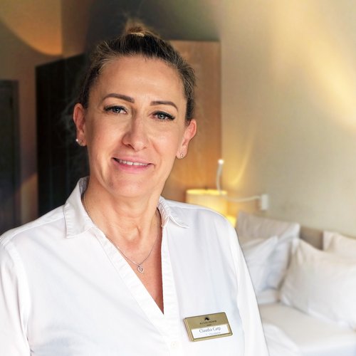 Our mission: your dream holiday in Oberstaufen Woman in white shirt with name tag in a hotel room