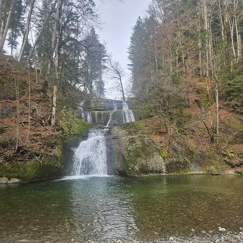 Die Tipps aus dem Wanderhotel im Allgäu Mehrstufiger Wasserfall in bewaldeter Herbstlandschaft mit klarem Wasser
