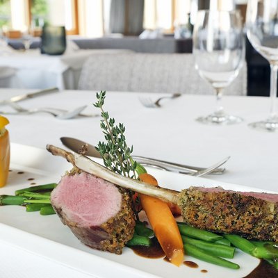 Hotel in the Allgäu region: 5 stars for your health Gourmet lamb chops with vegetables and stuffed yellow pepper on white plate