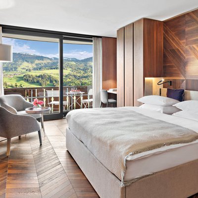 Urlaub im 5-Sterne-Hotel in Oberstaufen Modernes Hotelzimmer mit Holzakzenten und Bergblick vom Balkon
