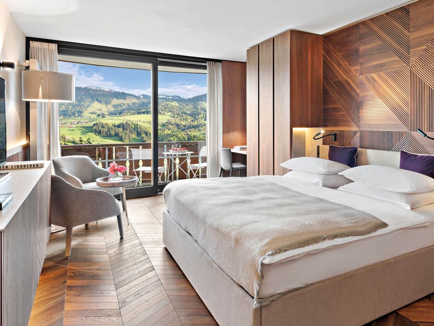 Longevity im Hotel in Deutschland im Allgäu Modernes Hotelzimmer mit Holzakzenten und Bergblick vom Balkon