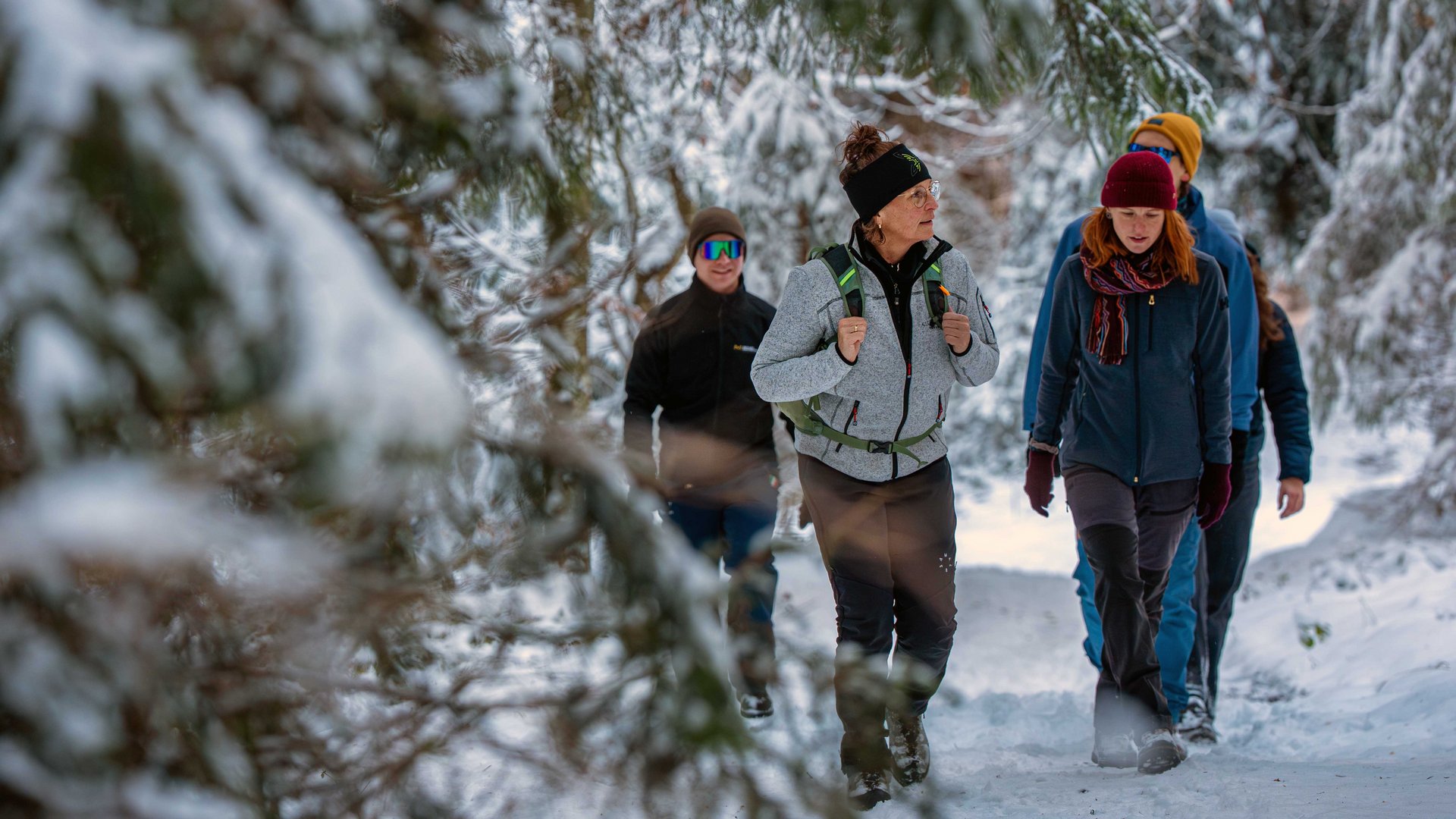 Ihr Wellnesshotel im Allgäu Menschen wandern winterlich gekleidet auf einem verschneiten Waldweg